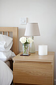 Bedside table lamp and cut flowers Gloucestershire England