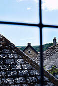 Die Dächer des Dorfes durch ein bleiverglastes Fenster betrachtet