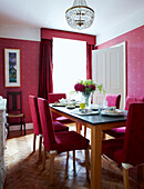 Esstisch mit rosa Stühlen, Vorhängen und Tapeten
