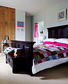 Patchwork quilt on black painted bed