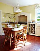 Holztisch und -stühle in einer gefliesten Küche