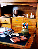 Pencils in holder and wooden drawers of writing desk