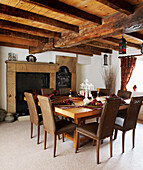 beamed ceiling in country style dining room with table and chairs