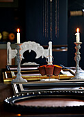 Lit candles and empty picture frames on dining table