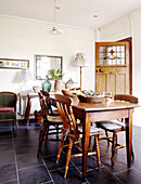 Wooden table and chairs in tiled kitchen of country house