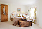 Fairy lights on headboard of bed with wooden trunk