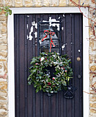 Christmas wreath hanging on black front door