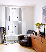 Brauner Ledersessel in einer Zimmerecke mit geteilten Fensterläden