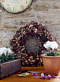 Christmas wreath and flowering plant on worktop with exposed stone wall