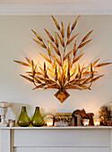 Decorative light fitting above mantlepiece with ornaments