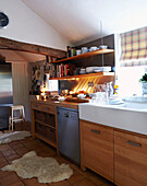 Holzeinbauküche mit Butler-Spüle unter einem Fenster mit Raffrollos