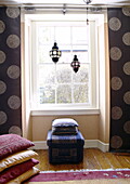 Moroccan lanterns hang at uncurtained window of living room in City of Bath Somerset, England, UK