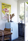 Scherzartikel-Figur und Poster mit hellblauem Vintage-Kühlschrank in der Küche eines Londoner Familienhauses UK