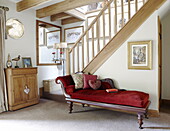 Chaiselongue aus rotem Samt im offenen Treppenhaus eines Landhauses in Hexham, Northumberland, England UK