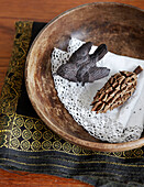 Bird ornament and pinecone with lace doilly in wooden bowl with gold and black fabric in Hastings home, East Sussex, UK