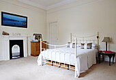 Storage baskets under double bed with white painted frame in Warwickshire home, England, UK