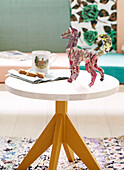 Modellhund auf rundem Holztisch mit Tasse und Keksen, Amsterdam, Niederlande