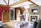 Wooden cabinets and check upholstered furniture in double height living room, Oxfordshire, England, UK