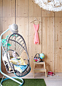 Hanging chair in panelled room with footstool in Mattenbiesstraat family home, Netherlands