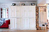 Painted storage cupboard with single word 'HOME' and cut logs in Derbyshire farmhouse England UK