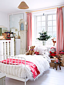 Kuscheltiere auf Einzelbett am Fenster im Kinderzimmer eines Bauernhauses in Derbyshire, England, UK