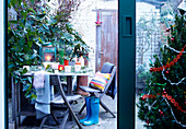 View through sliding door to backyard with folding chairs and table London home England UK