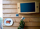 Wall mounted television in wood clad dining room of London family home England UK