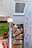 Schuhe auf einer Treppe mit Astro-Rasen und Kinderzeichnungen an der Wand eines Londoner Familienhauses England UK