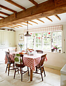 Holzstühle mit roter und weißer Tischdecke in einer Bauernhausküche in Surrey England