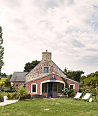 Deck chairs in garden of rural Brittany school conversion with brick extension France