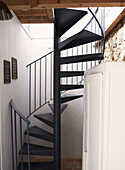 Black metal spiral staircase in schoolhouse conversion Brittany France