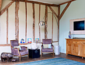 Wooden sideboard and arco lamp with matching upholstered chairs in living room of Nottinghamshire barn conversion England UK