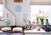 Kitchen utensils and cut tulips with Aga at kitchen window in Nottinghamshire barn conversion England UK