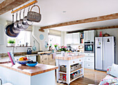 Saucepans hang in beamed kitchen of Nottinghamshire barn conversion England UK