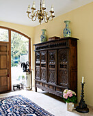 Carved wooden storage unit in entrance hall of traditional country house Welsh borders UK