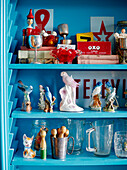 Papageienfiguren mit altem Spielzeug auf hellblauem Regal in einem Haus in Auckland auf der Nordinsel Neuseelands