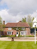 Water fountain and facade of detached brick Buckinghamshire home UK