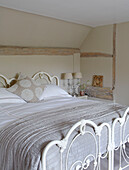 Cream quilt on double bed with metal footboard in Buckinghamshire home UK