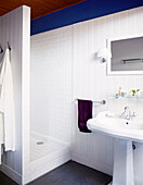Duschkabine und Waschbecken mit lila Handtuch in einem Gästehaus in der Bretagne, Frankreich