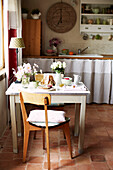 Vintage-Stuhl am Frühstückstisch mit Schnittblumen in einem bretonischen Bauernhaus Frankreich