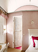 Dried flowers hang above window with open door from Brittany bedroom France