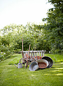 Garten mit alten verzinkten Eimern und altem Heuwagen