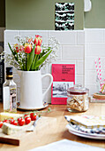 Krug mit Tulpen und Käseplatte in einer Küche in Kent, England, UK