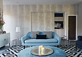 Light blue sofa and ottoman with black and white patterned rug in 19th Century Grain Mill conversion Scottish Borders, UK