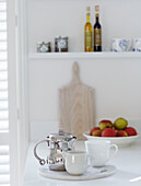 Metallische Kaffeekanne mit Milchkännchen und Tasse auf der Küchenarbeitsplatte mit Äpfeln in einem Stadthaus in York England UK