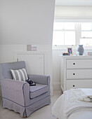 Light grey striped cushion on upholstered armchair in York townhouse bedroom England UK