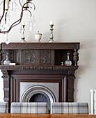 Carved wooden fireplace with glass and silverware in Northumbrian country house UK