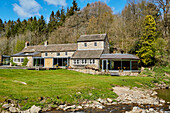 Renoviertes Mühlenhaus aus dem 18. Jahrhundert in einem Waldgebiet in Northumbria, UK