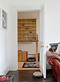 Wall mounted shelf unit viewed through opened door in Country Durham home, North East England