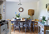 Landwirtschaftliche Geräte und Küchentisch mit bemalten Stühlen in einem Cottage in Northumberland, Tyne and Wear, England, UK